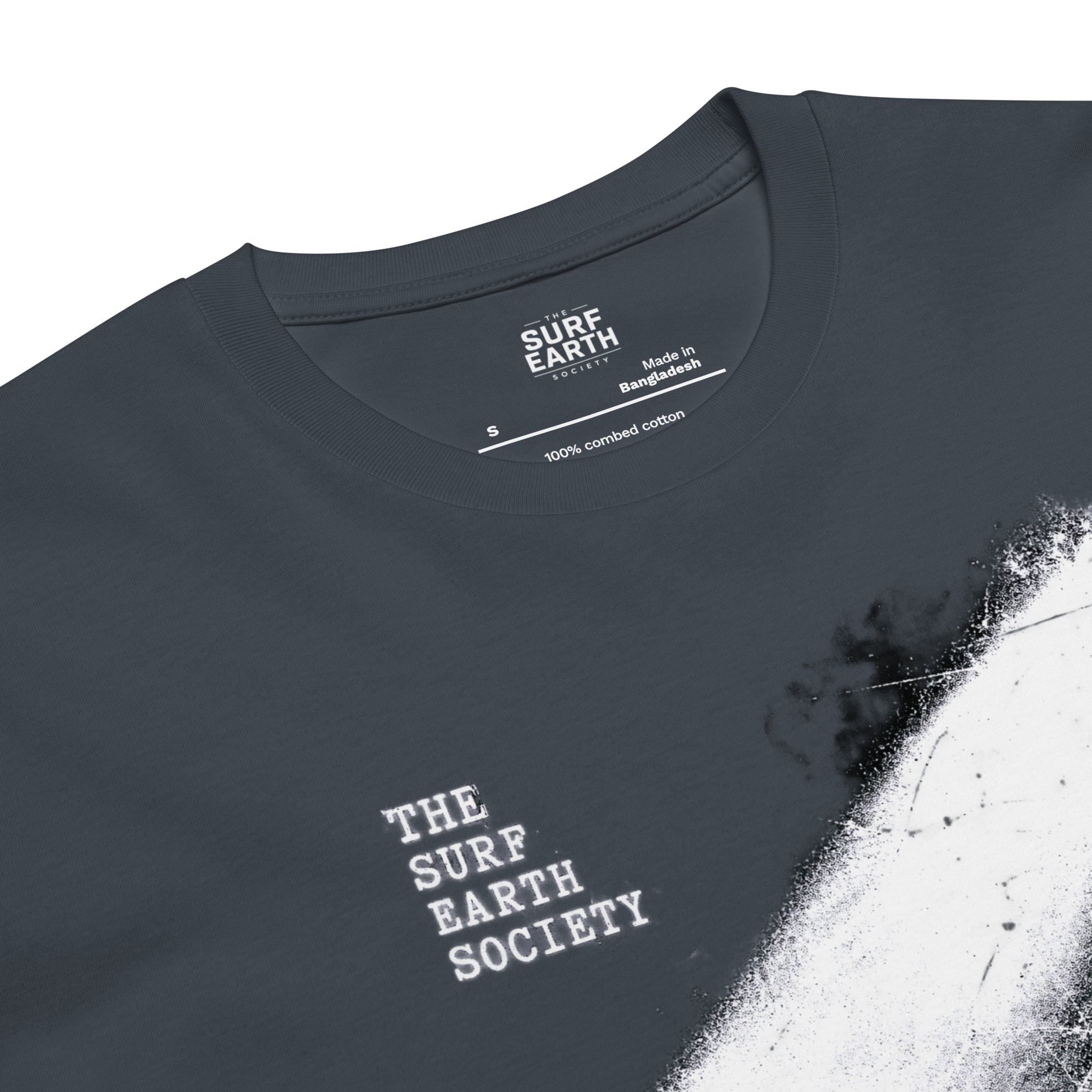 Close-up of a petrol blue gray t-shirt with a white distressed paint-splatter graphic on the right side and 'THE SURF EARTH SOCIETY' printed in white on the chest. The inner collar label shows 'SURF EARTH SOCIETY' and 'Made in Bangladesh'.